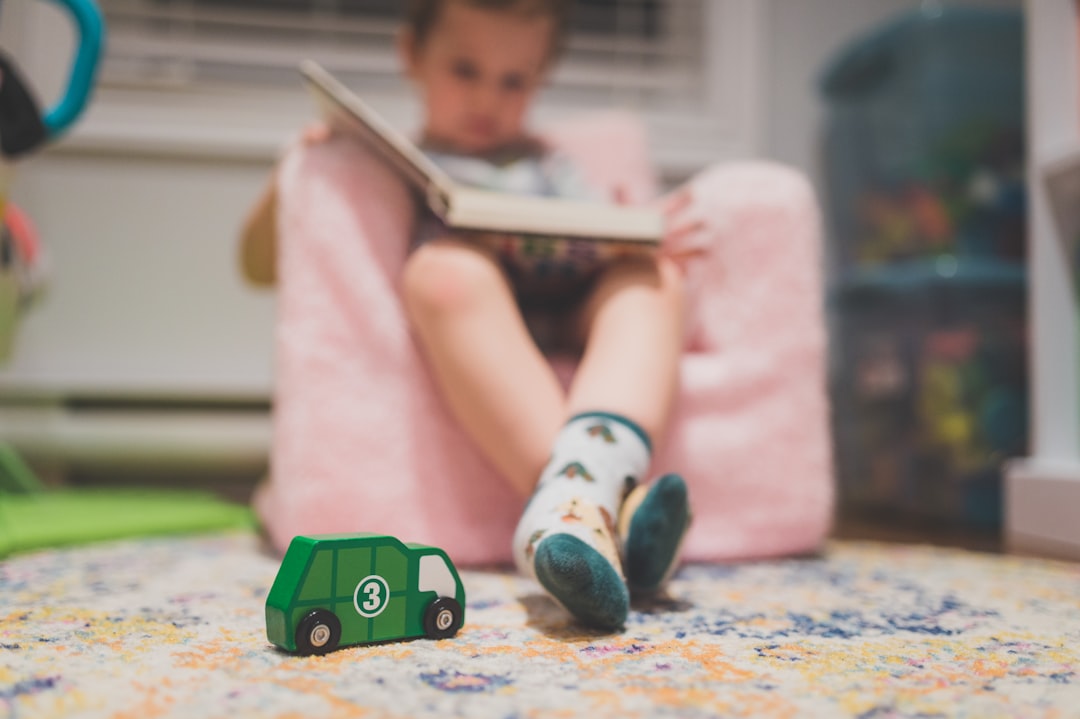Child sitting in a chair reading a book to build reading fluency with high-frequency words