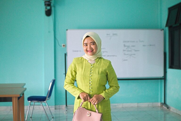 ESL teacher smiling in front of whiteboard teaching listening skills