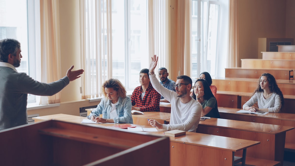 ESL students raising hands to practice pronunciation in a classroom