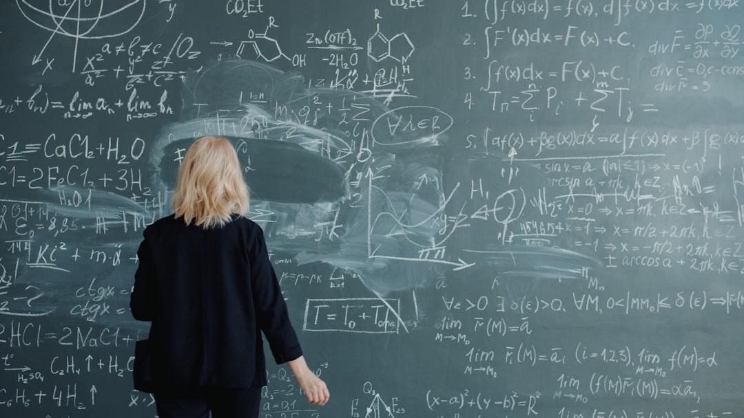 Woman looking at a blackboard with complex math equations.