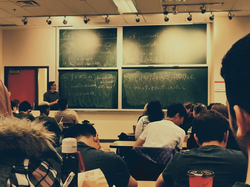 Students sitting in front of a chalkboard learning English in a multilevel class