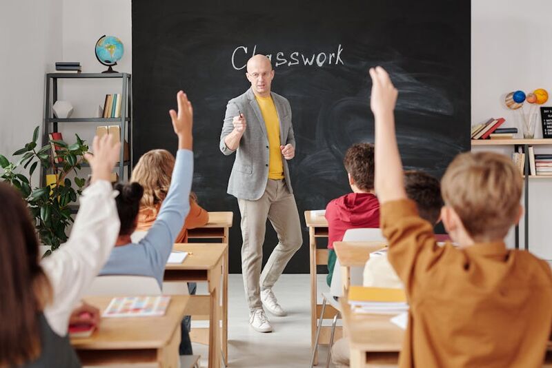 Students raising hands during a warm up activity in English class