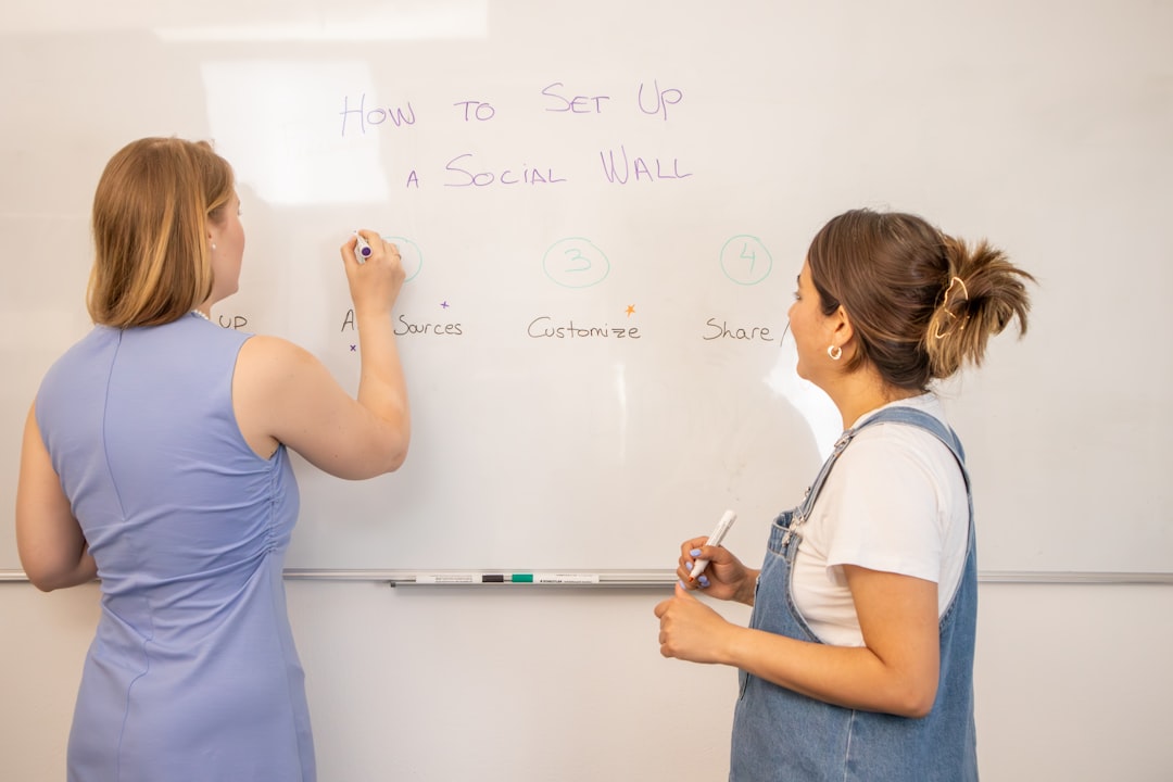 Marketing team discussing the steps for setting up a social wall in front of a white board