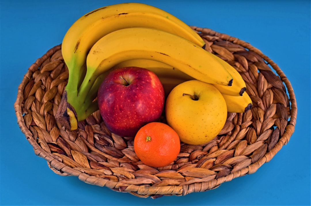 colorful display of fruit including bananas, apples and an orange