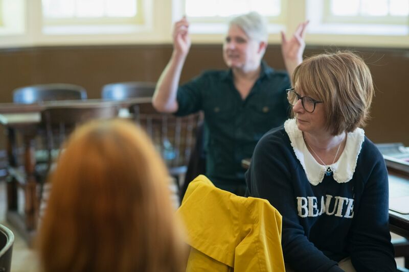 Adult ESL students working independently after reduced teacher talk time