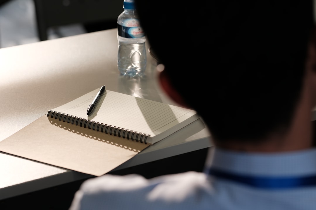 Girl drawing in notebook with mask nearby