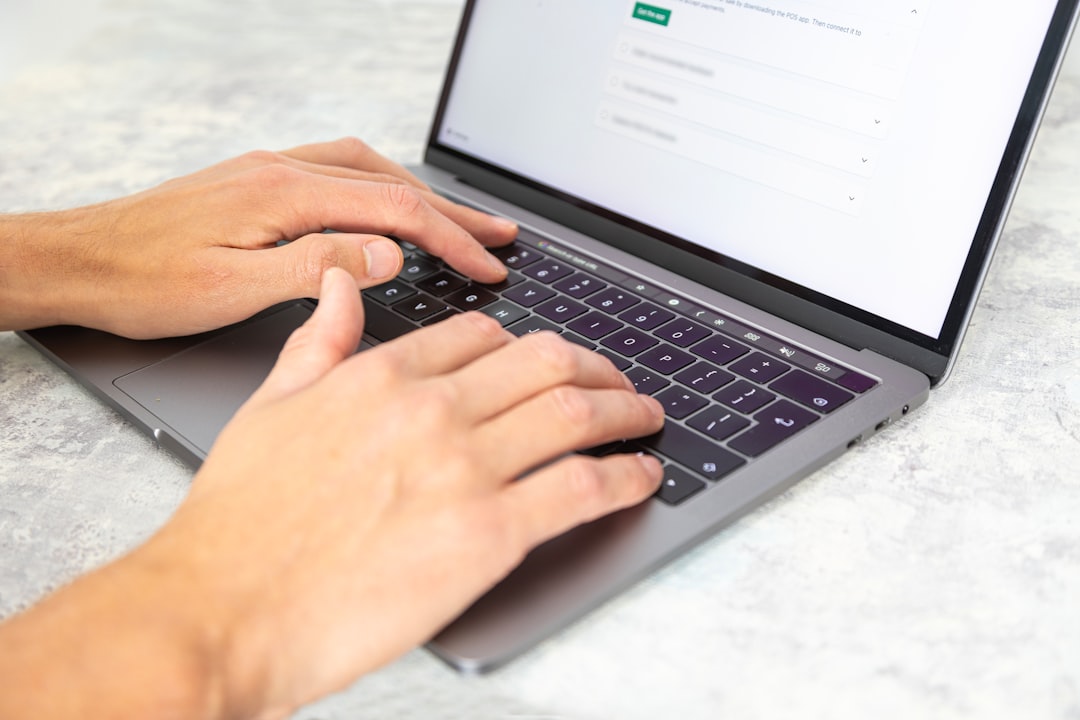 Caucasian hands using a professional laptop to edit a website and write copy. With a plain background.