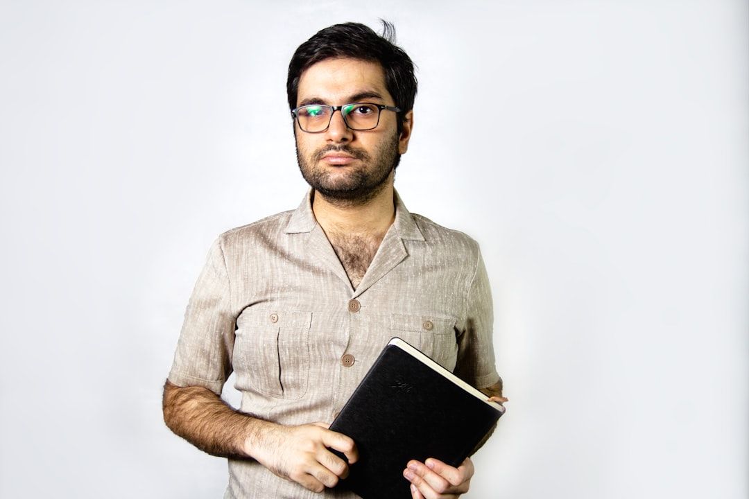 man in brown button up shirt holding black tablet computer