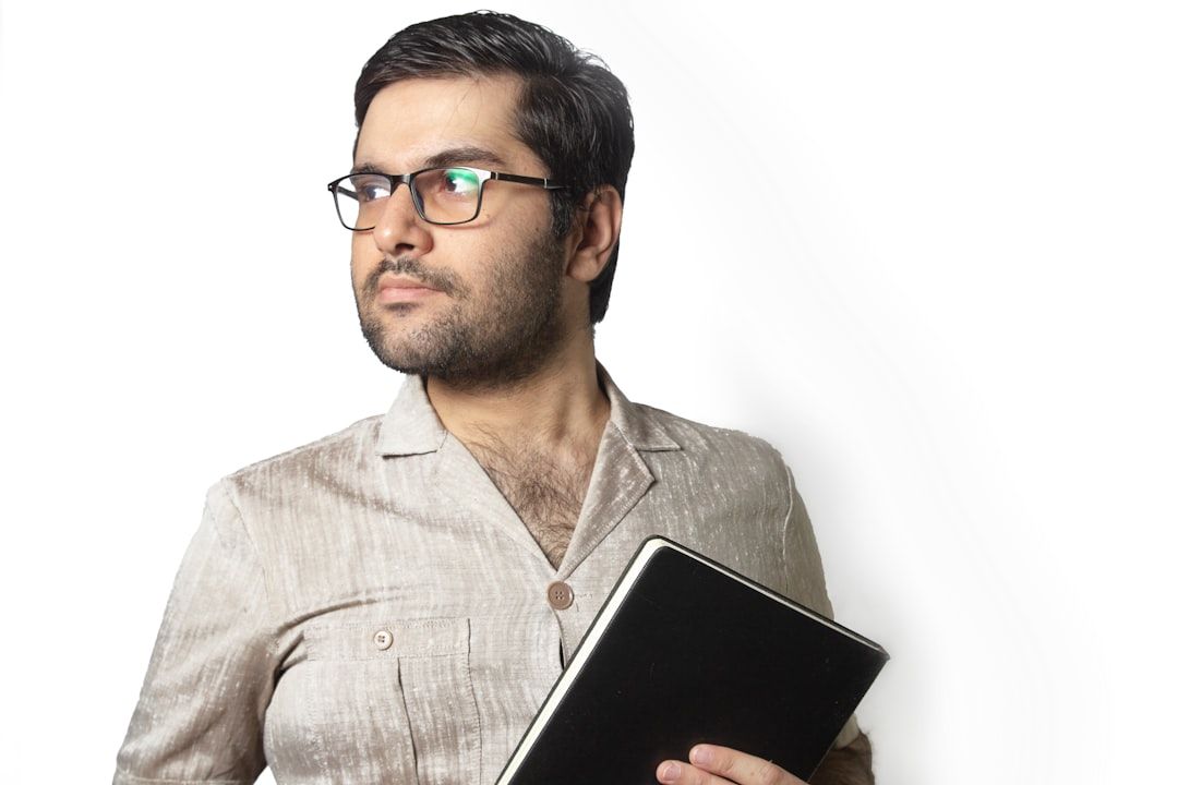 man in gray dress shirt holding black tablet computer