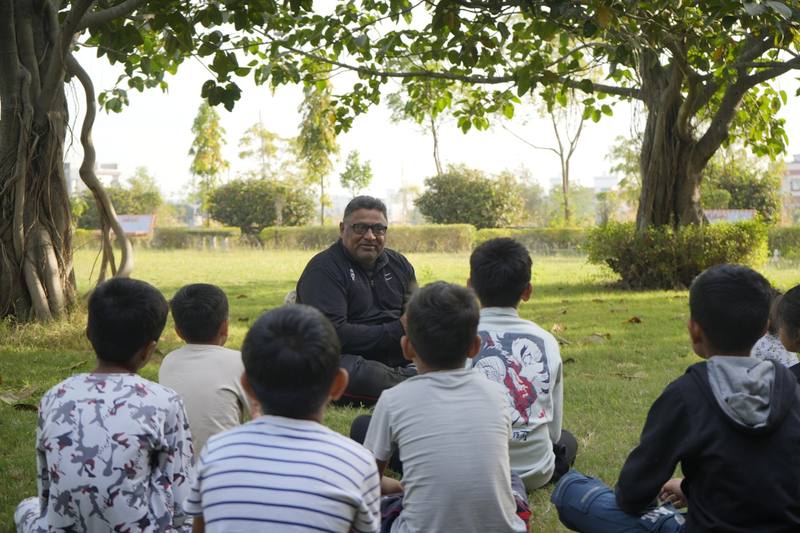Teacher leading a TPR storytelling session with seated young learners