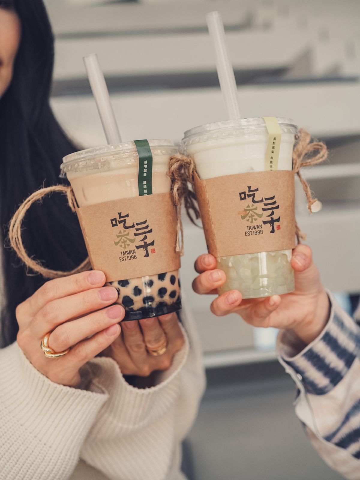 Two friends clinking Taiwan-branded bubble tea cups