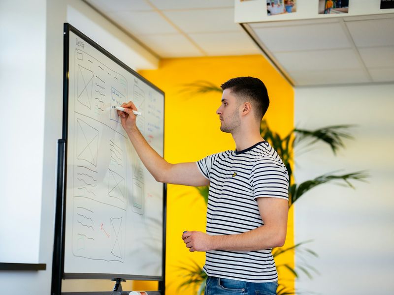Teacher writing concept check questions on the whiteboard during a grammar lesson