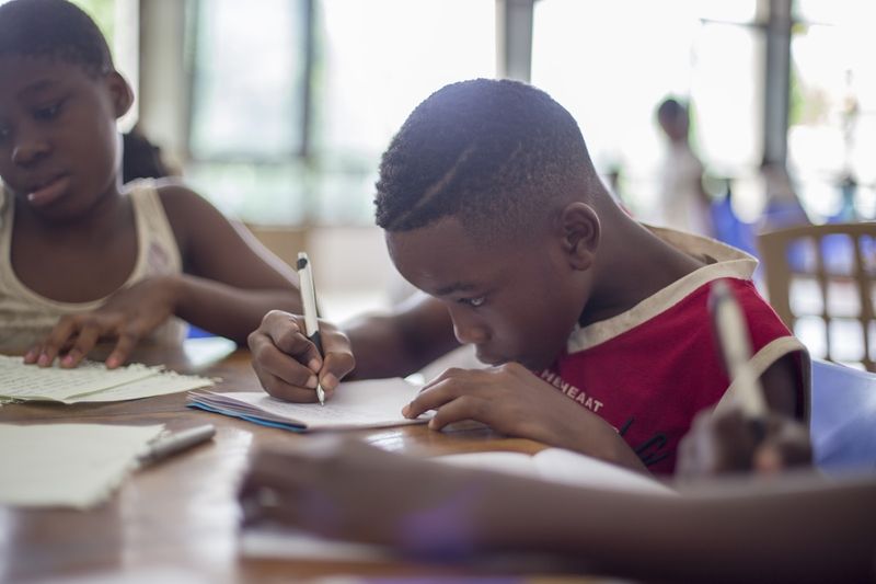 Young learners practicing English tense verbs in writing exercises