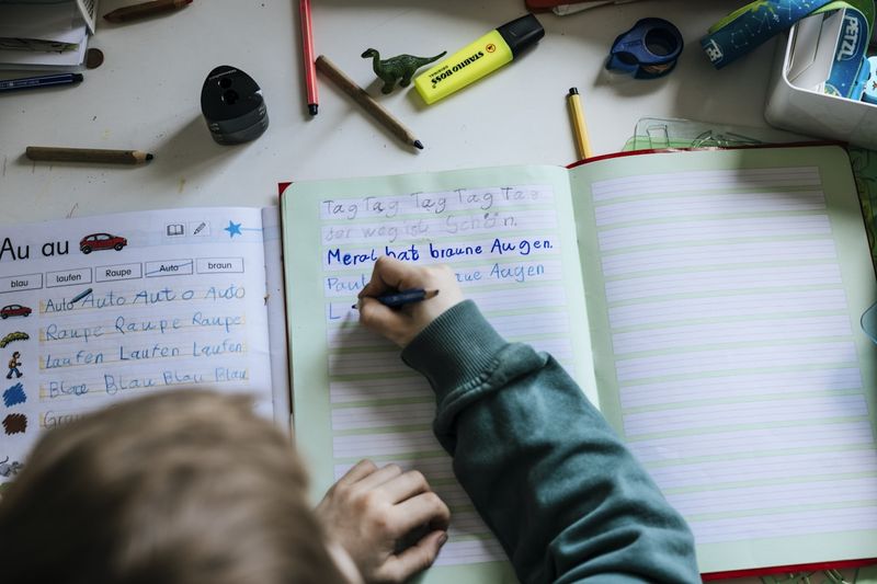 Student writing elicited vocabulary into a notebook