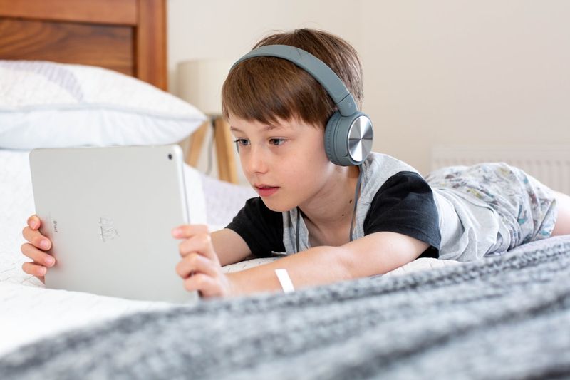 Beginner English learner using headphones for comprehensible input listening practice