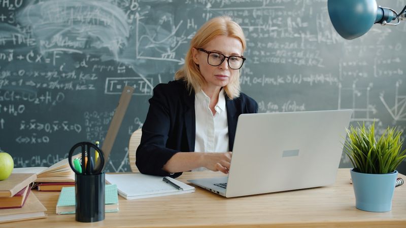 Teacher building an ESL pronunciation lesson plan at her desk