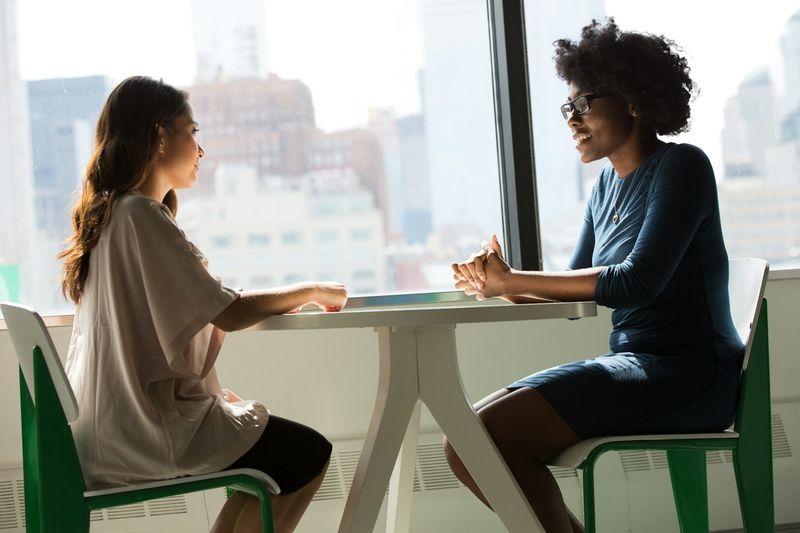 Two ESL students practicing a role play conversation in pairs
