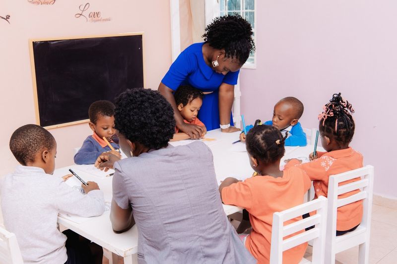 ESL teacher leading a flashcard activity with young learners around a table
