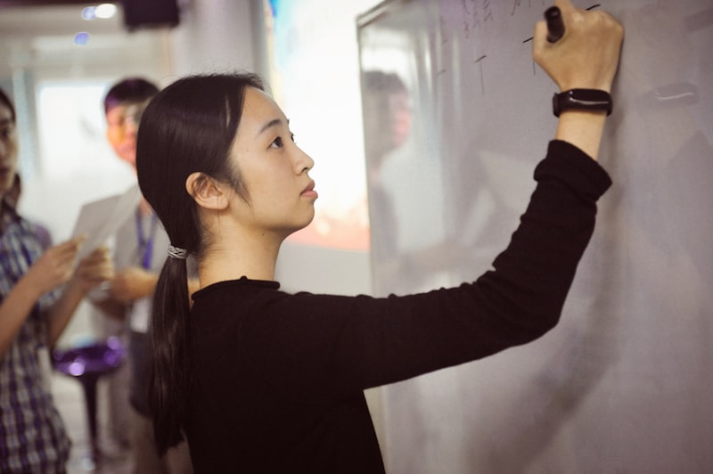 ESL teacher writing learning objectives on a classroom whiteboard for backward design lesson