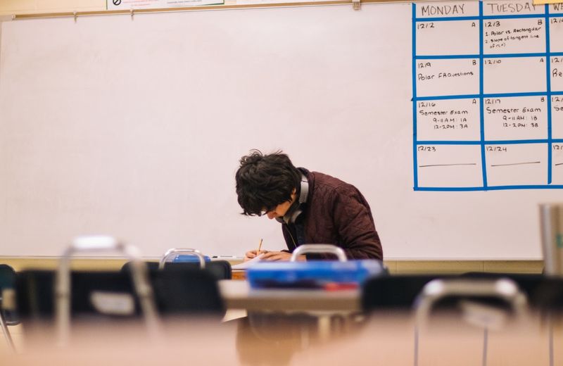 Student practising ESL writing prompts at a classroom desk