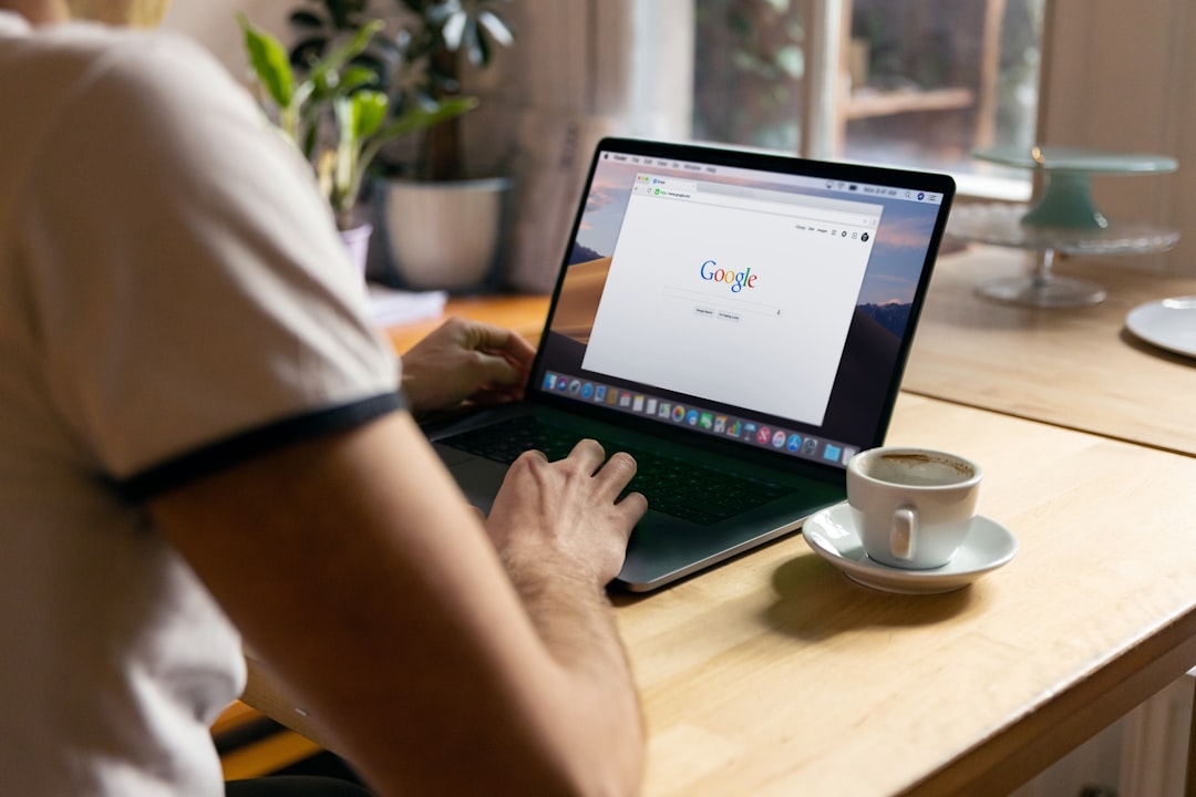 Man uses Apple MacBook in a cafe or restaurant. He is searching Google website. Free editable PSD here: https://firmbee.com/u