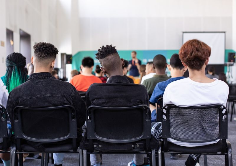Diverse ESL students seated at orientation on the first day