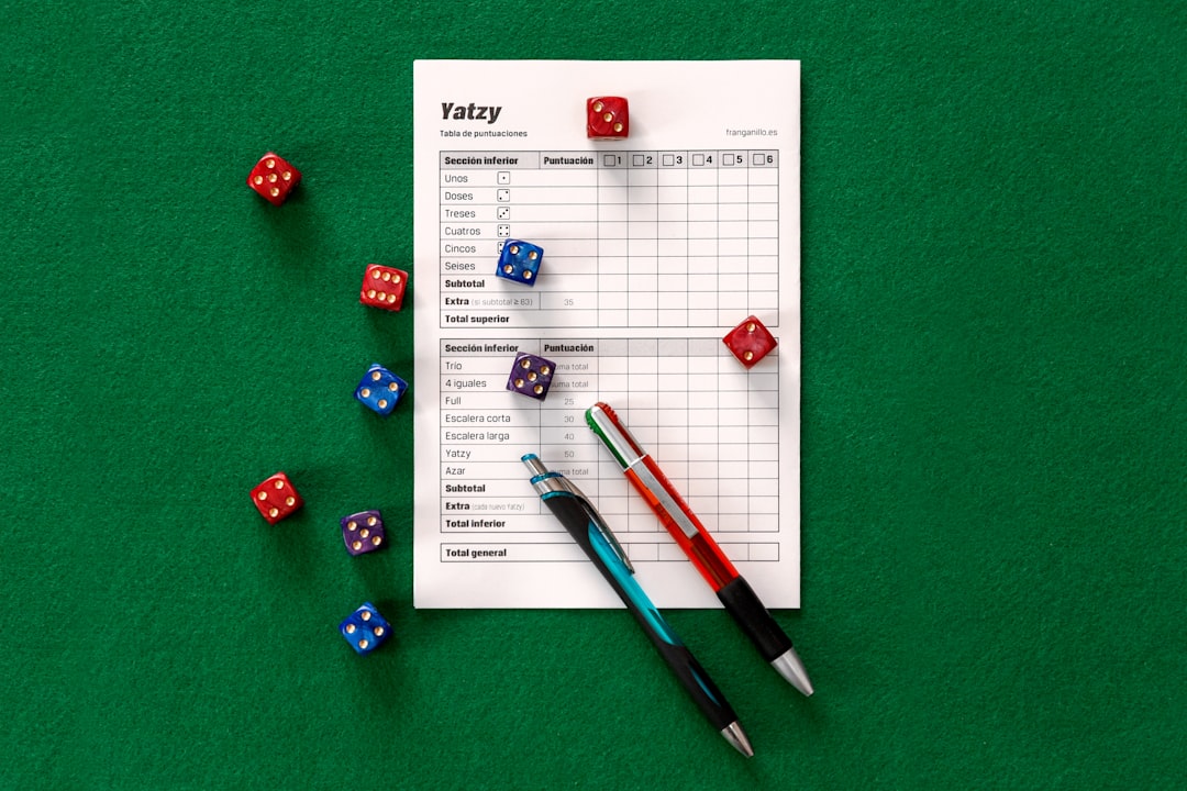 Assorted-color dice on green surface. Yatzy is a public domain dice game similar to Yacht and Yahtzee (trademarked by Hasbro