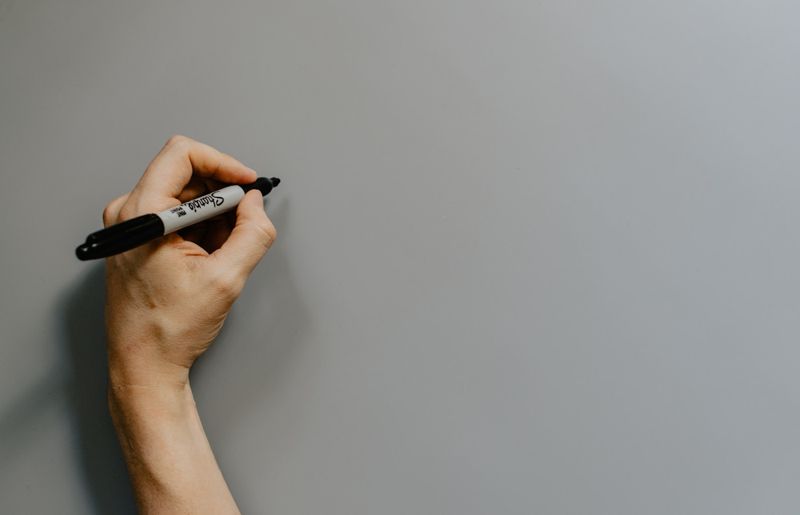 Teacher demonstrating teaching the passive voice on a classroom whiteboard