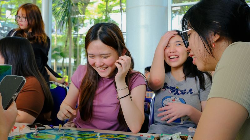 ESL students playing a vocabulary board game and laughing