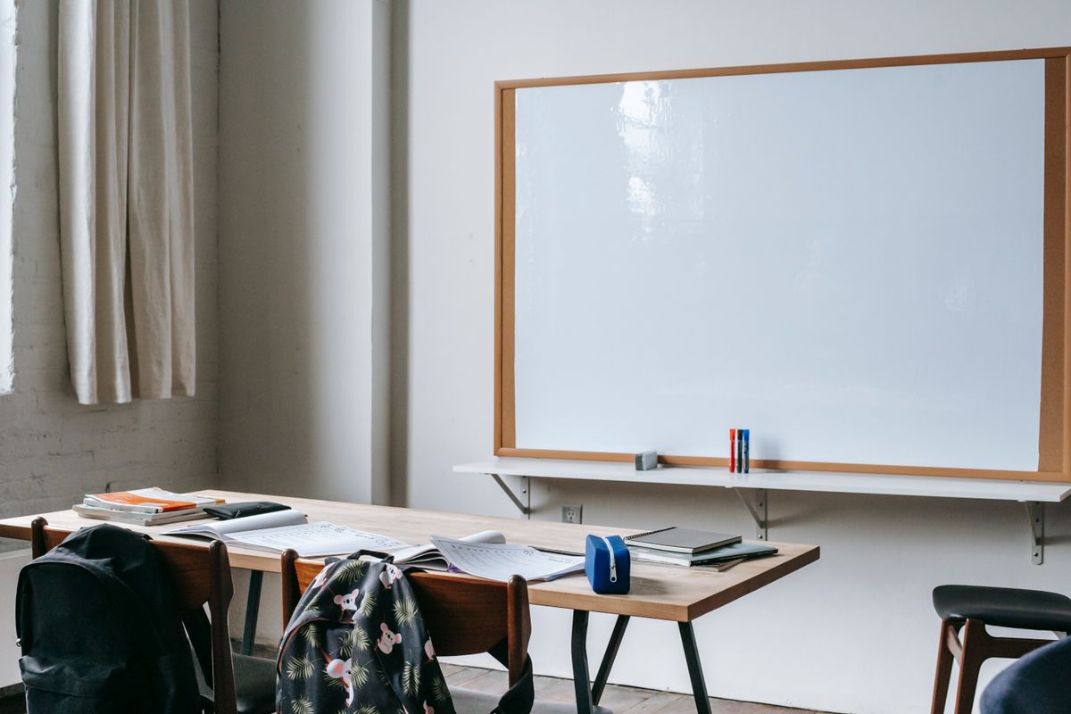 ESL classroom with whiteboard and open workbooks on a desk, representing calibrating test difficulty without a pilot group