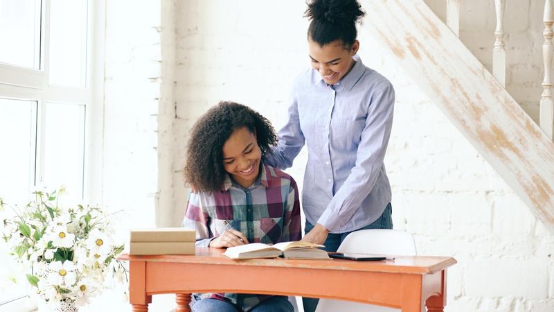 Teacher using error correction in ESL with a student's book