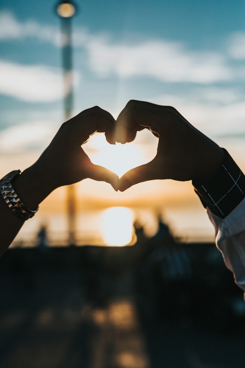 Pink heart in hands — fall head over heels English idiom about falling in love