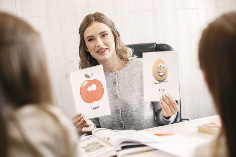 ESL teacher using picture flashcards to teach comparative adjectives