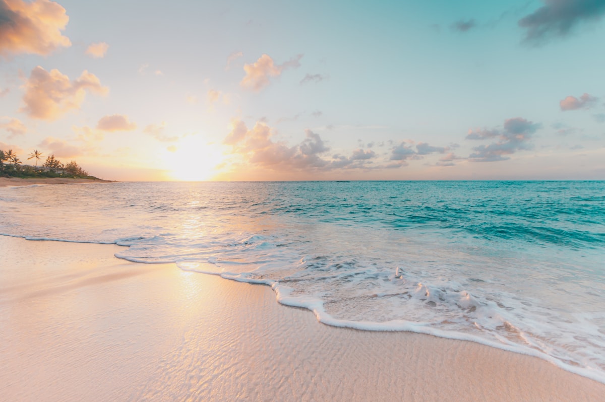 Calm turquoise waves rolling onto a golden sunset beach, the perfect change of scenery Calm turquoise waves rolling onto a golden sunset beach, the perfect change of scenery