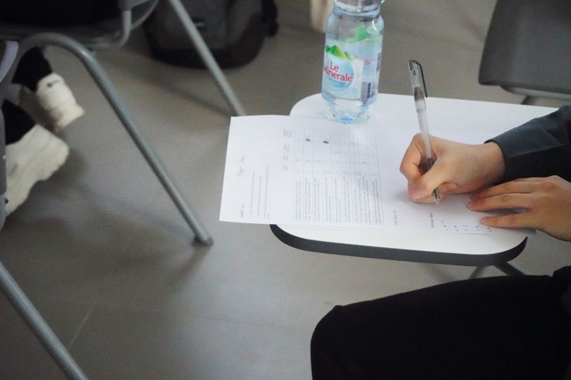 ESL student completing a passive voice writing assessment at a desk