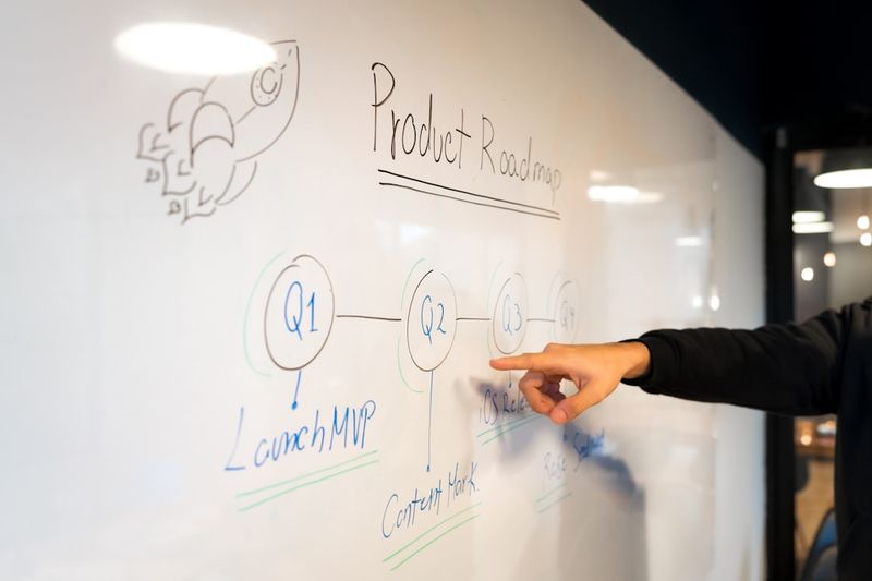 teacher writing question formation rules on English classroom whiteboard