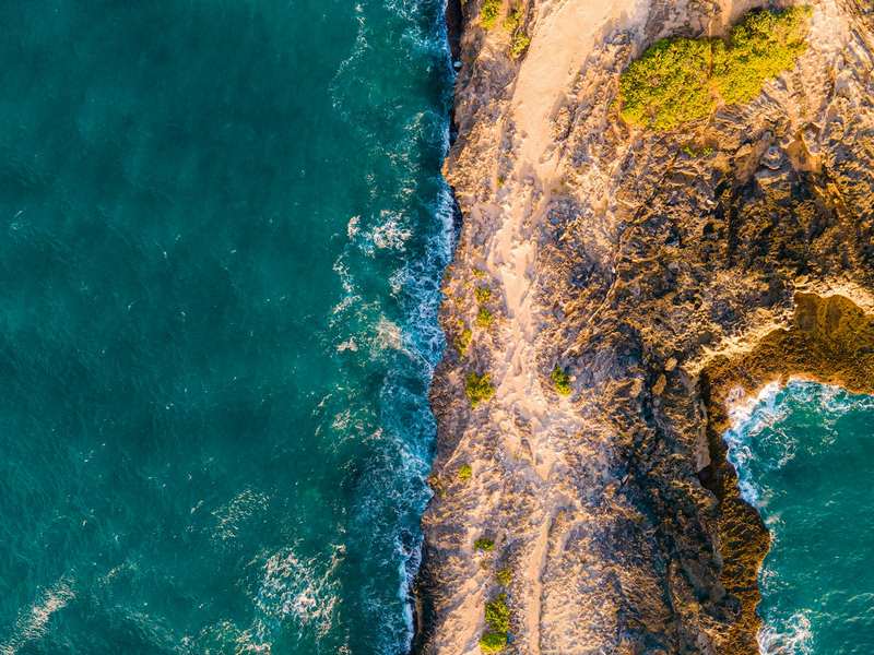 Aerial view of a rugged island coastline used as a Robinson Crusoe lesson prompt
