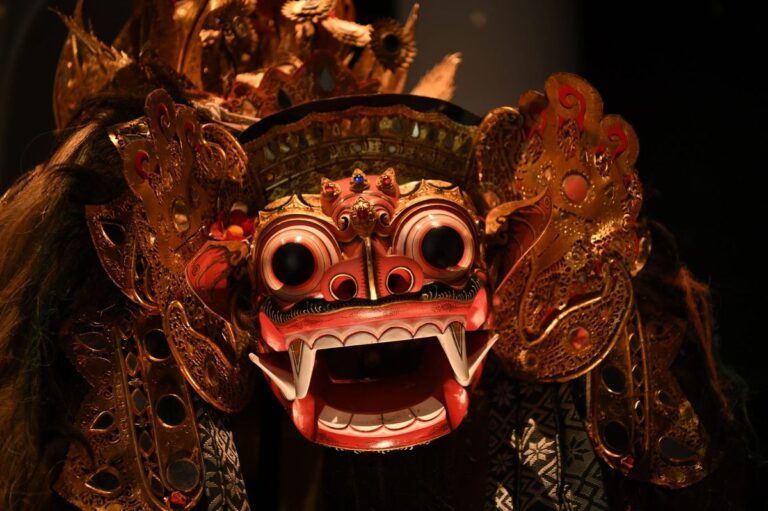 A detailed image of a traditional Balinese Barong mask with rich golden and red colors.
