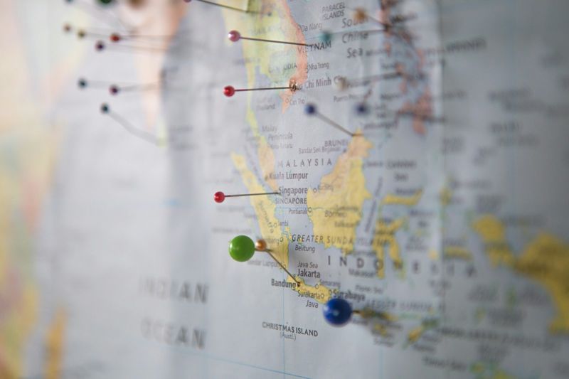 A world map with pins used as realia for teaching countries and travel English in the classroom