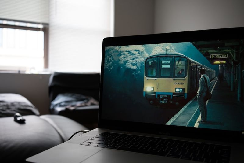 ESL homework activity — student watching English movie on laptop at home