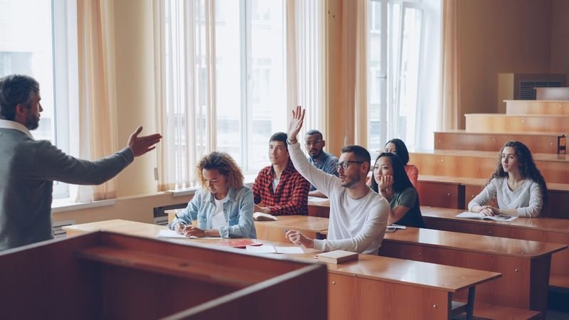 ESL student raising hand to ask a question during question formation practice