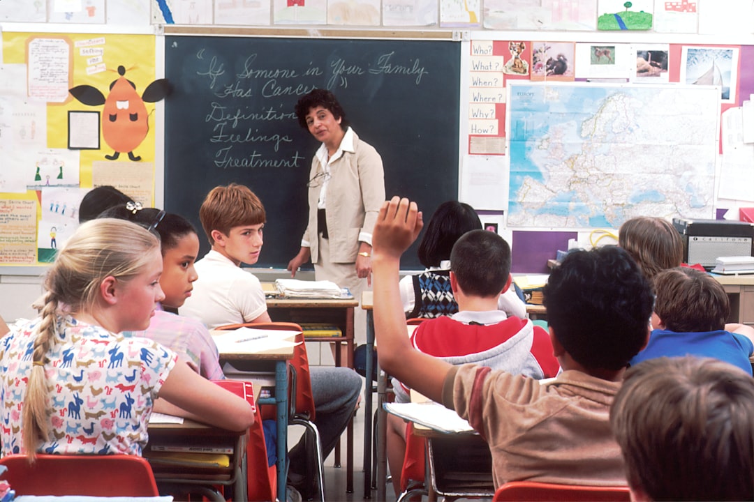 Children in a Classroom. In the back of a classroom, are children about 11 years old with a female teacher talking about the