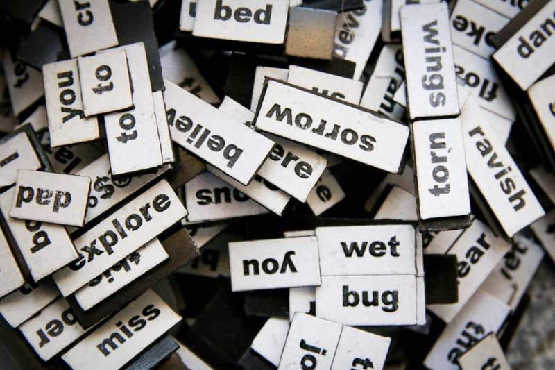 Wooden letter tiles spelling out adjective vocabulary for order of adjectives practice