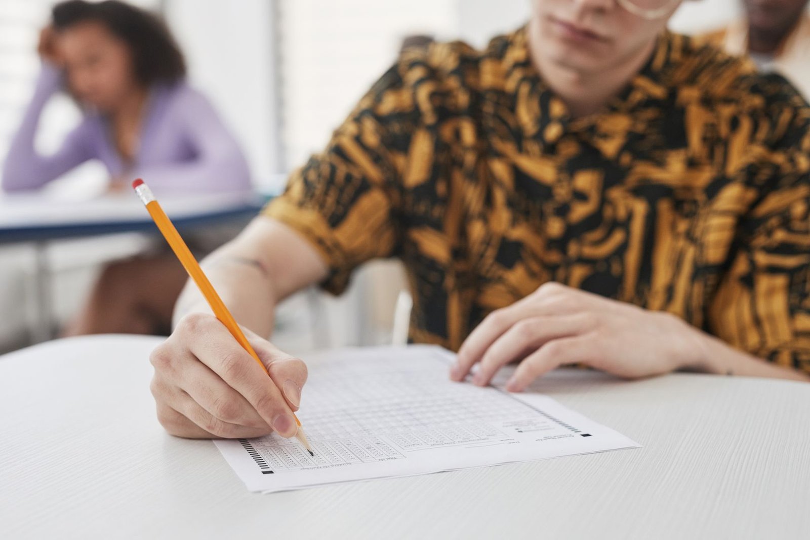 Student writing on an exam paper during TOEIC or IELTS test practice