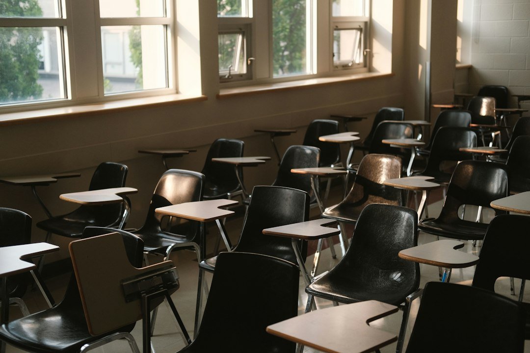 Empty classroom with desks and chairs by windows