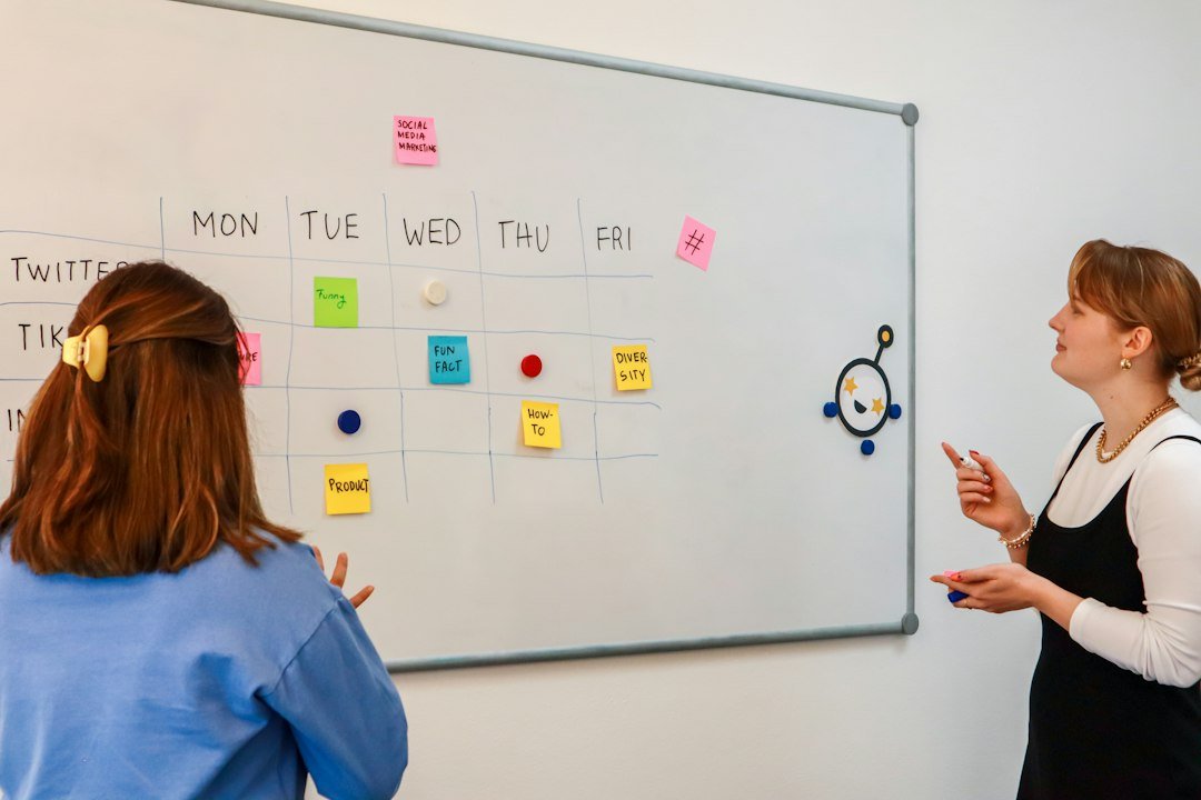 Marketing team planning weekly content for social media in front of a white board