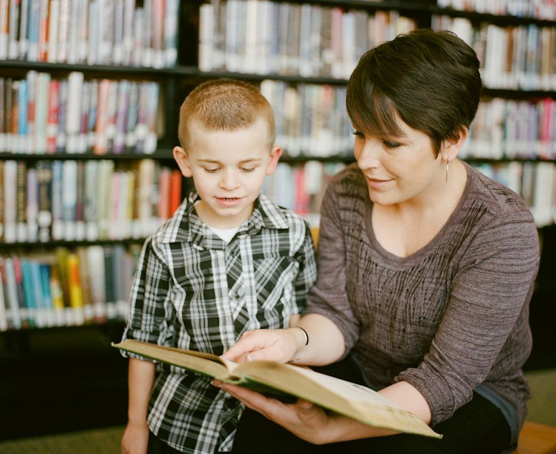 ESL teacher reviewing reading record with student to track extensive reading progress