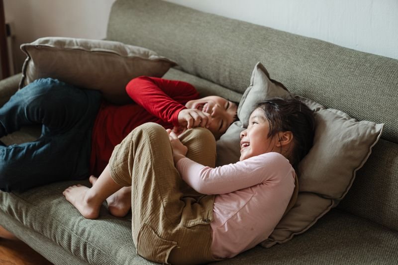 Siblings laughing together representing close-knit family idioms