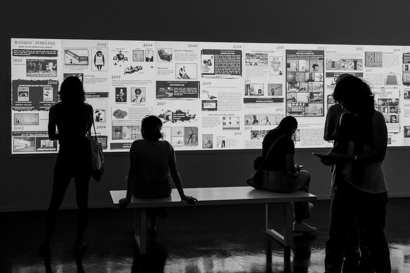 People comparing two displayed images side by side during a visual comparison gallery walk