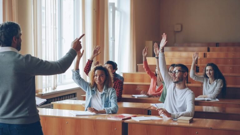 teacher pointing at esl students with raised hands during grammar auction bidding